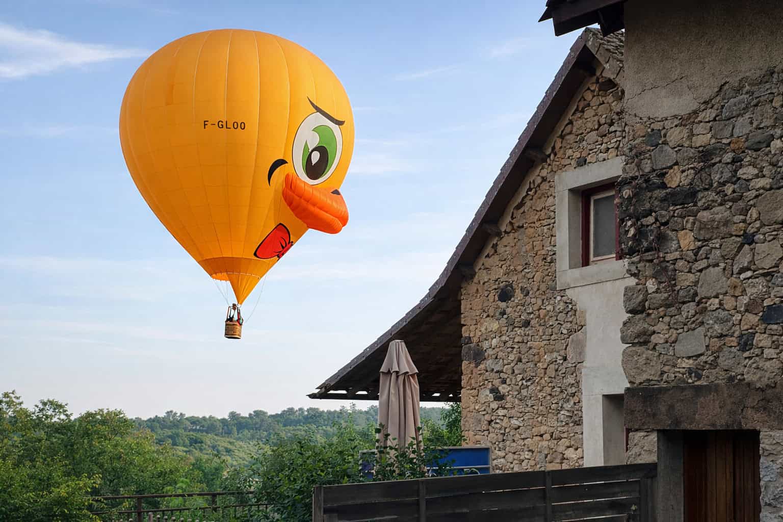 Duck-shaped hot air balloon with a cheerful face and bright orange beak.