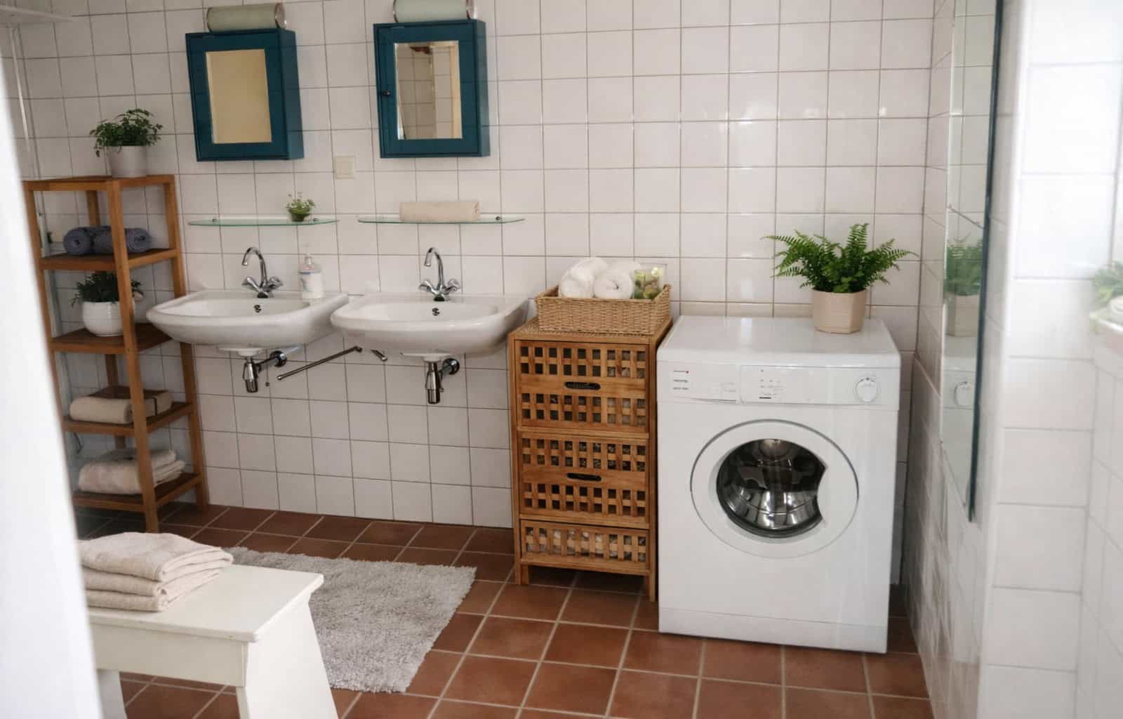 Laundry room with washing machine, dual sinks, and storage shelves in a modern, bright space.